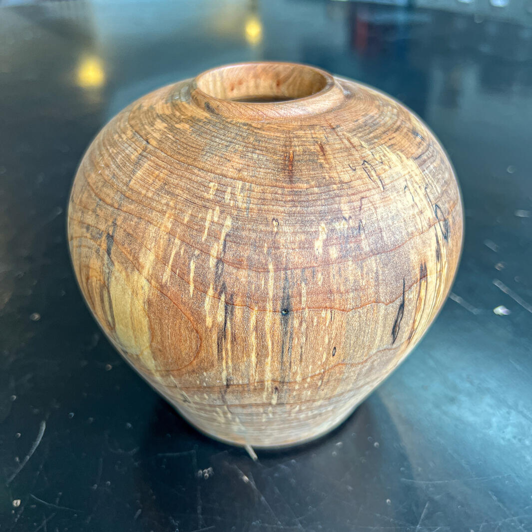 Spalted maple vase on a black table
