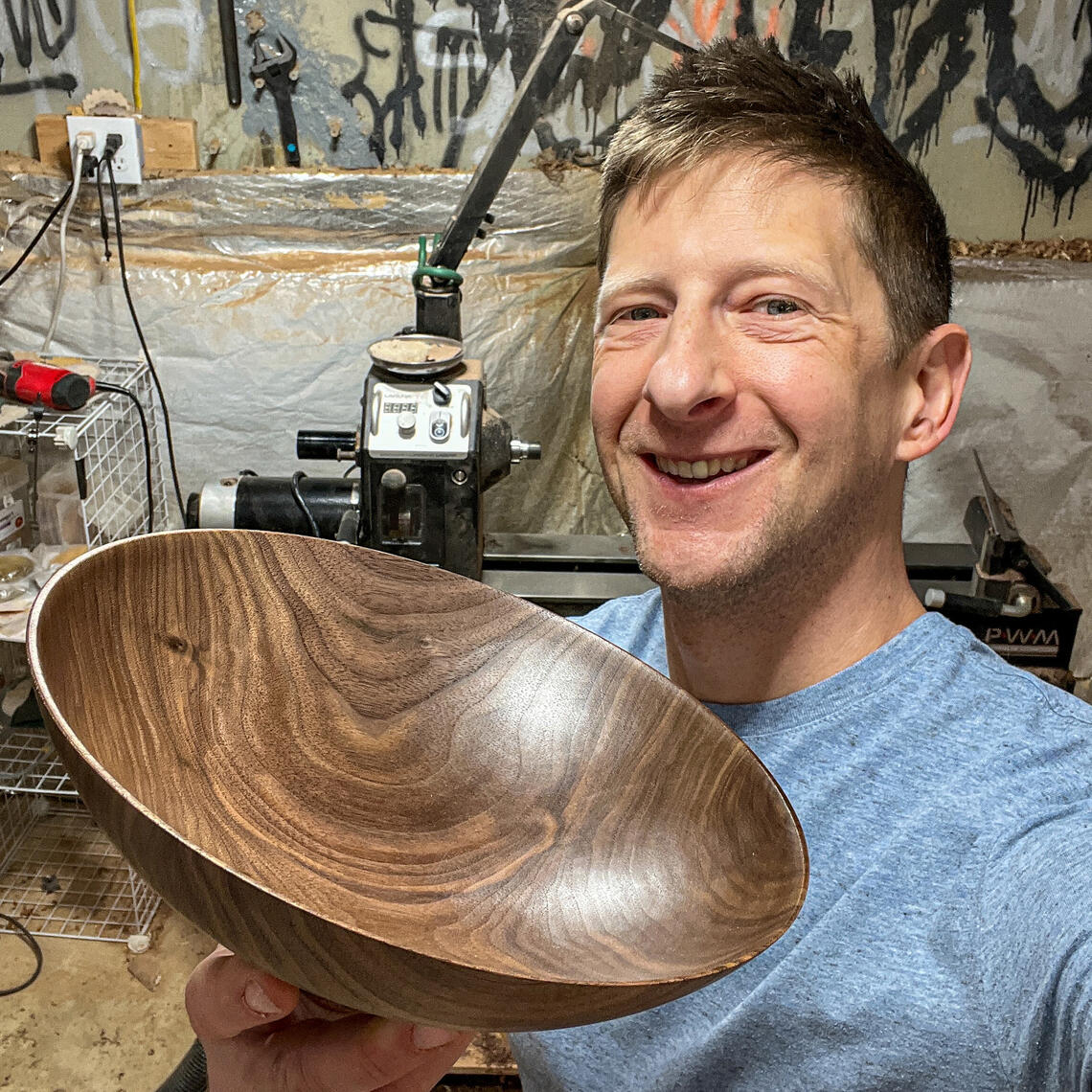 The naked woodturner holding a walnut bowl that he made